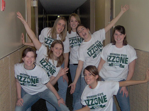Several students posed in the hallway of a residence hall, wearing matching Ozone shirts